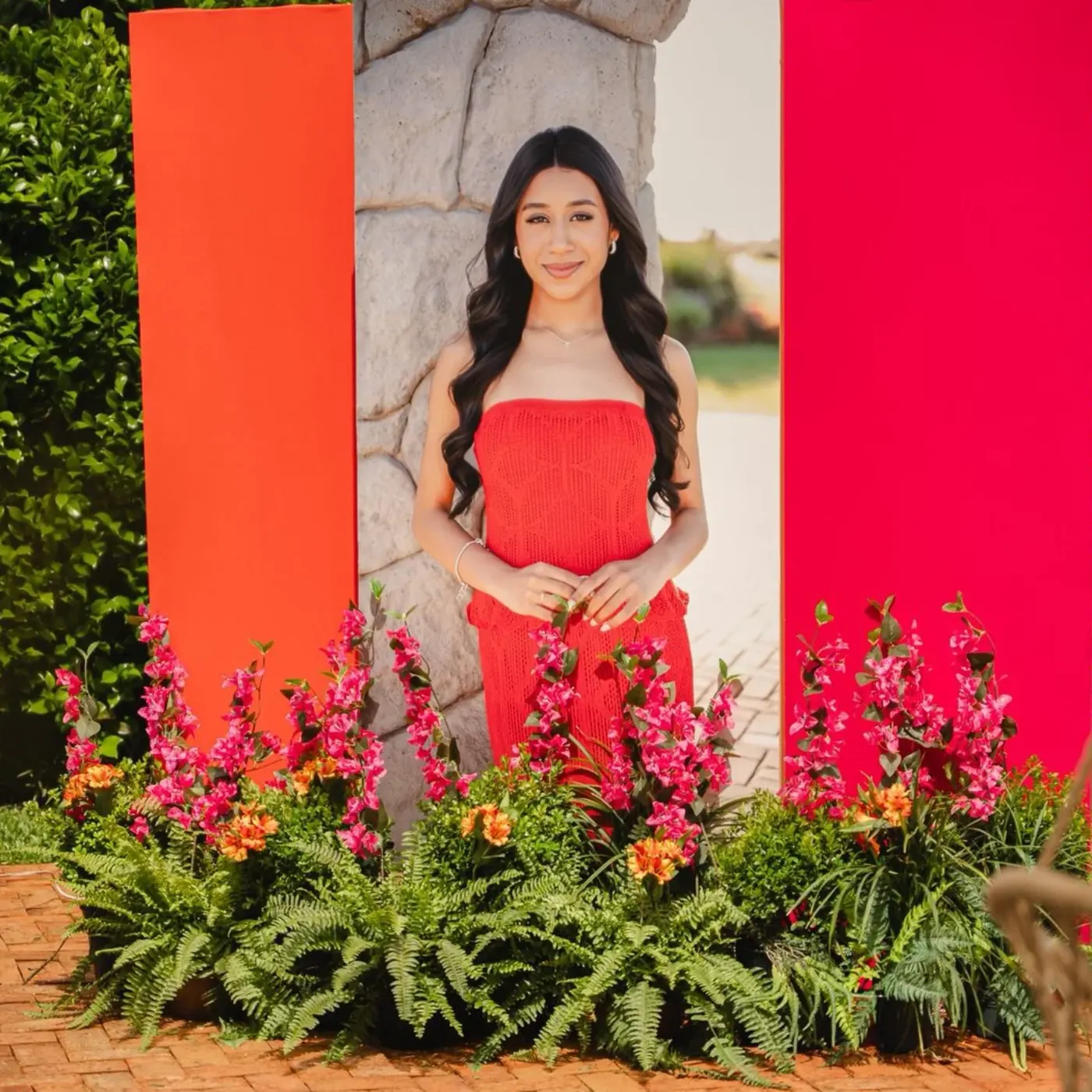 Debutante de vestido vermelho entre flores